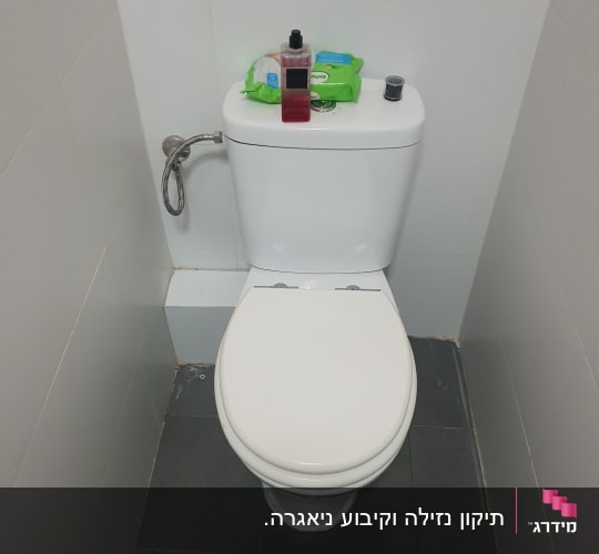 אסלה עם צינור מים מחובר לקיר